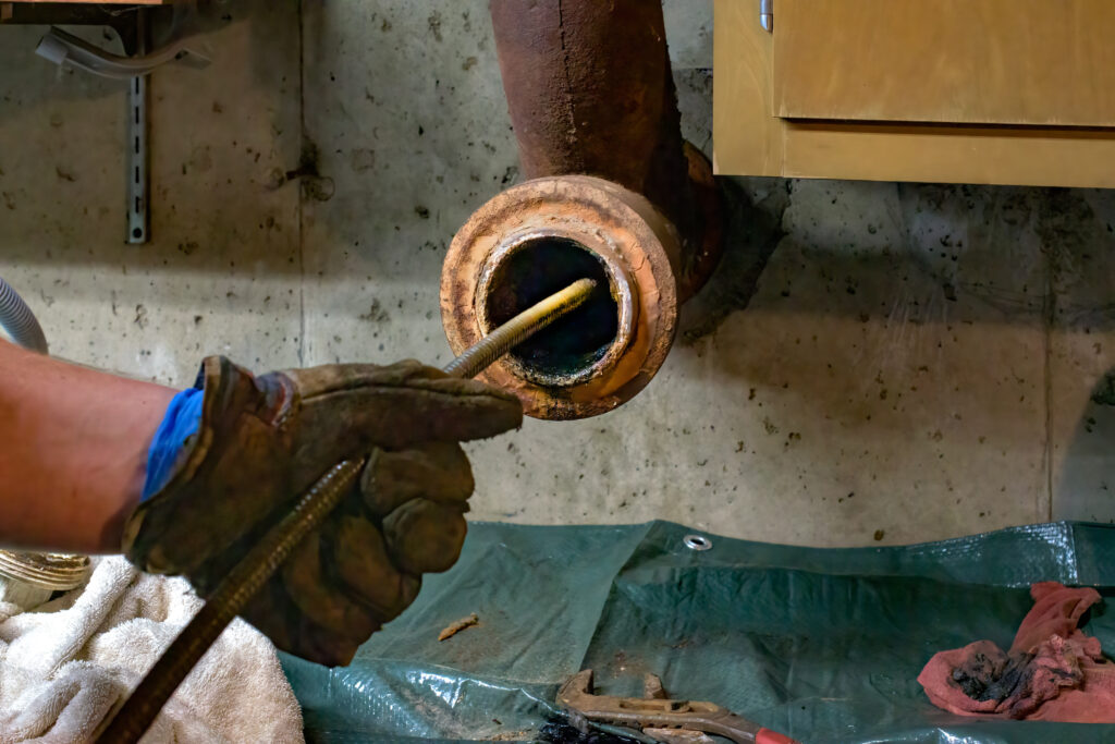 A picture of a plumber cleaning a pipe